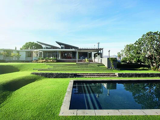 Piscine avec membrane armée RENOLIT ALKORPLAN 2000 Noir, effet miroir devant une maison contemporaine