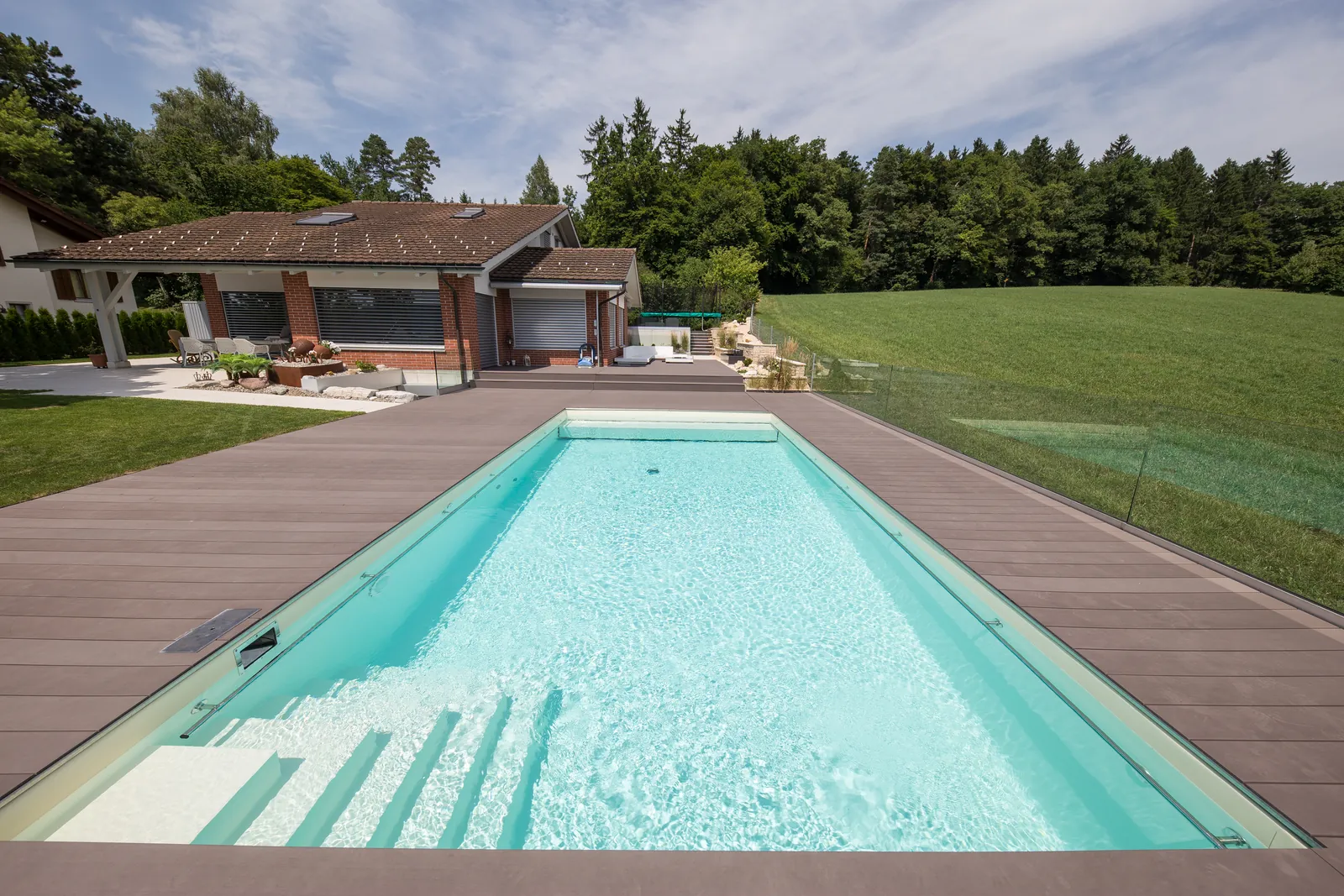 Piscine avec membrane armée RENOLIT ALKORPLAN 2000 Sable, eau turquoise aux reflets beiges devant une maison contemporaine