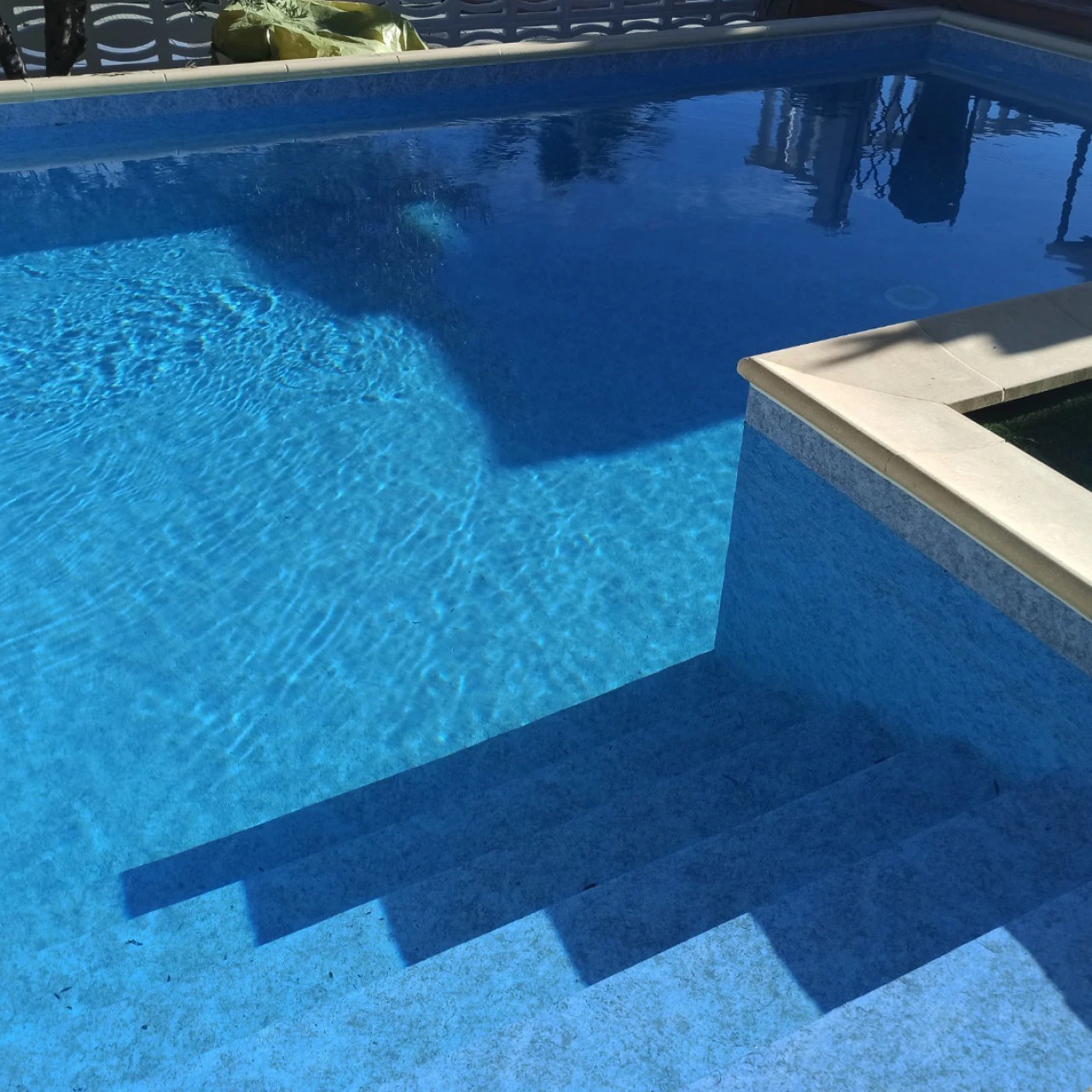 Piscine avec membrane armée BWT Be BRANE 3D Surface Midnight Blue, eau bleu nuit profond avec marches et reflets de palmiers