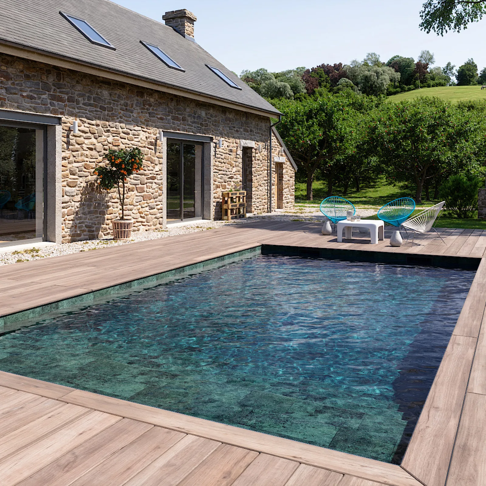 Piscine avec membrane armée BWT Be BRANE 3D Surface Natural Green, eau bleu-vert profond devant une maison en pierre et terrasse en bois