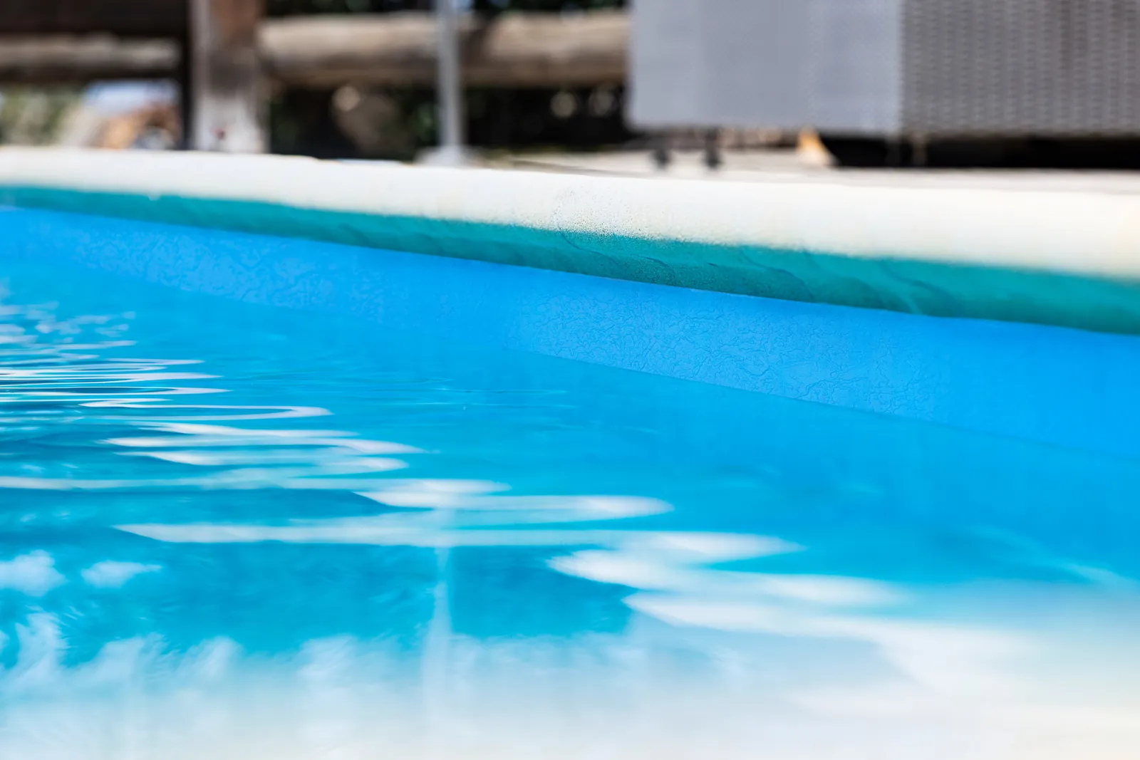 Piscine avec membrane armée RENOLIT ALKORPLAN Relief Bleu Adriatique, paroi texturée bleu profond vue au ras de l’eau
