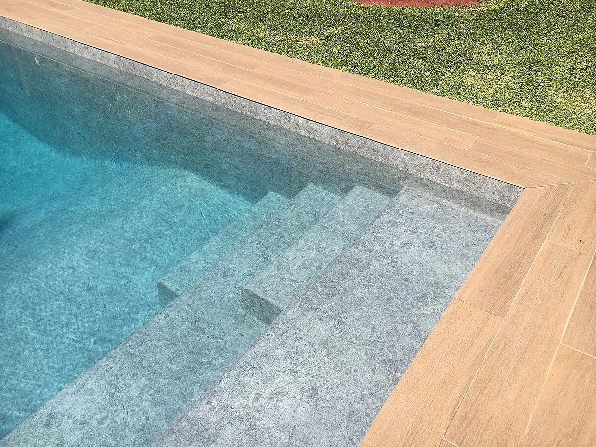 Piscine avec membrane armée RENOLIT ALKORPLAN Touch Prestige, effet roche volcanique vue sur les marches