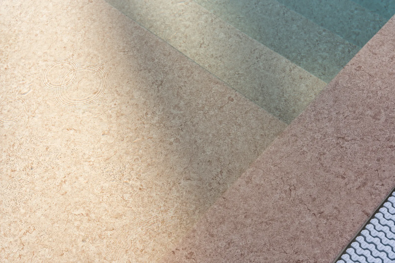 Marches de piscine avec membrane armée RENOLIT ALKORPLAN Touch Sublime, effet travertin rosé et eau vert d’eau