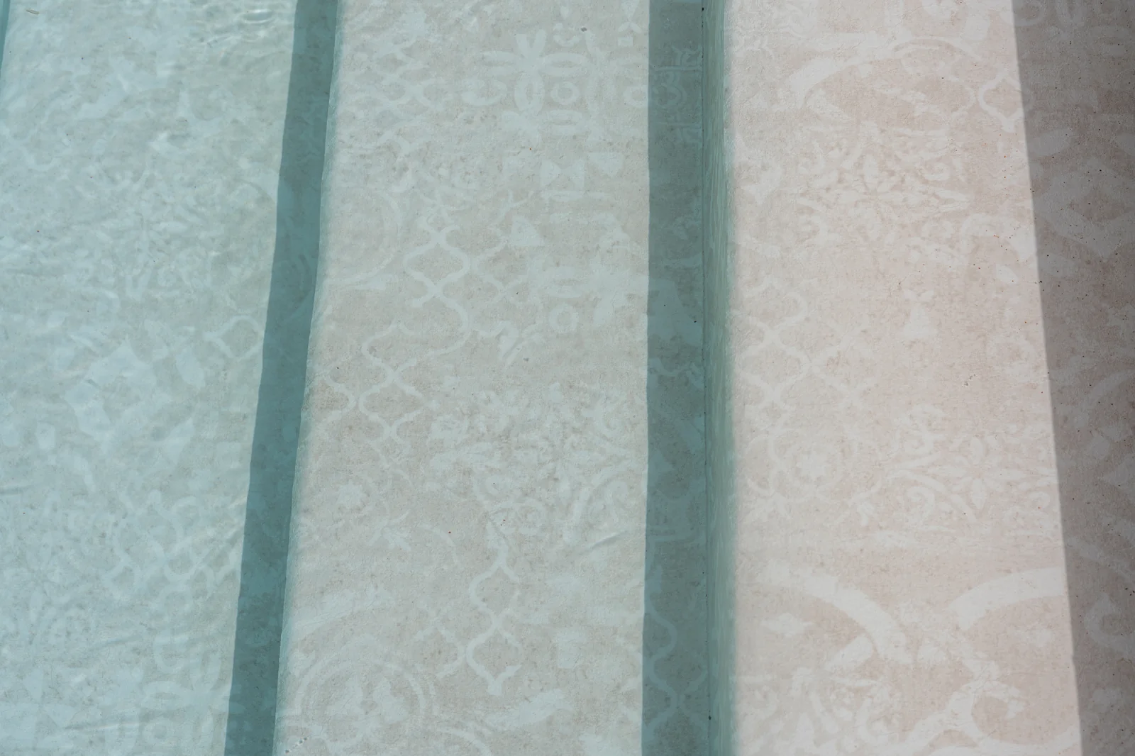Marches de piscine avec membrane armée RENOLIT ALKORPLAN Vogue Vintage, motif carreau de ciment beige vu sous l’eau